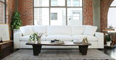 a living room with a white couch and coffee table in front of a large window