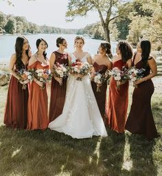 a group of women standing next to each other on top of a grass covered field