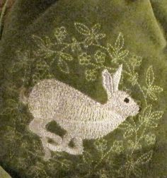 an embroidered rabbit on a green cloth