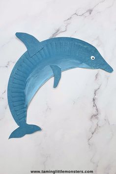 a paper plate dolphin on a marble surface