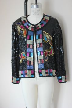 "What a beauty!! This Stunning Judith Ann Creations heavily beaded cropped jacket is just beautiful..great way to dress up your evening! There is one hook and eye at the top..which makes the top very versatile. Very good condition.. i do not see any missing beads and there is terrific trim as well as beads throughout. Measuring: length:21\" Width: 40\" Sleeve length: 22\" A real M/L Pet Free/smoke free Enjoy!" Spring Party Embellished Outerwear, Fitted Embellished Party Outerwear, Glamorous Beaded Outerwear For Evenings, Glamorous Beaded Evening Outerwear, Glamorous Beaded Party Outerwear, Beaded Fitted Outerwear For Night Out, Fitted Multicolor Evening Outerwear, Fitted Beaded Evening Outerwear, Vintage Beaded Party Outerwear