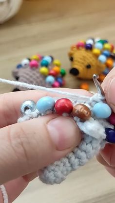 someone is crocheting beads on the end of a piece of yarn