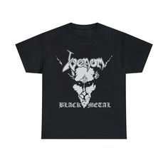 Black Venom t-shirt with the iconic Black Metal album graphic printed on the front in white. Premium 100& cotton unisex tee. Venom are an English heavy metal band formed in Newcastle upon Tyne in 1978. Coming to prominence towards the end of the new wave of British heavy metal, Venom's first two albums, Welcome to Hell (1981) and Black Metal (1982), are considered major influences on thrash metal and extreme metal in general. Their second album proved influential enough that its title was used as the name of the black metal genre; as a result, Venom were part of the early wave of the genre, along with Mercyful Fate and Bathory. The quintessential classic cotton t-shirt, this Gildan Heavyweight Tee is the centerpiece for any combination of t-shirt basics. 100% preshrunk cotton means the siz Black Metal Band Shirts, Black Metal Clothing, White Gothic T-shirt For Streetwear, Black Band Merch T-shirt With Logo, Alternative Style Black T-shirt With Logo Print, Black Band Merch Shirt For Fans, Gothic Black Shirt With Graphic Print, Black Gothic Shirt With Graphic Print, Black Band Merch Shirt With Sublimation Print