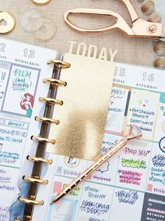 a planner with gold foil on it next to a pair of scissors and some other items