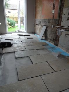 a black cat laying on the floor in an unfinished room that is being remodeled with blue tape