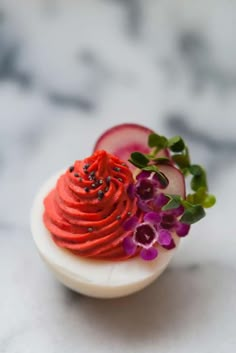 a plate with some food on top of it and purple flowers in the middle,