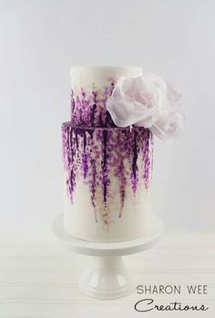 a white and purple cake with flowers on top