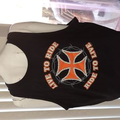 a black shirt with an orange and white cross on the front is hanging from a window sill