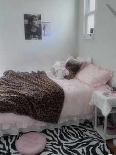 a bedroom with a zebra print rug and pink bedding