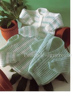 knitted sweaters and potted plant in front of green wall