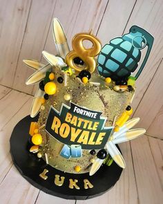 a cake with gold frosting and decorations on the top that says fortnite battle royale