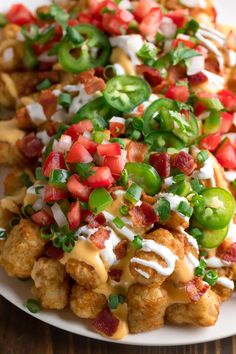 a white plate topped with tater tots covered in cheese and veggies