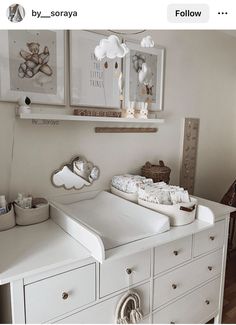 a baby's crib in the corner of a room with pictures on the wall