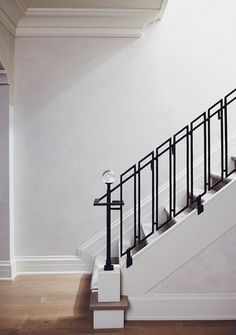 an empty room with white walls and black railings