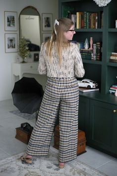 a woman standing in front of a bookshelf with her back to the camera