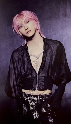 a woman with pink hair and piercings posing for a photo