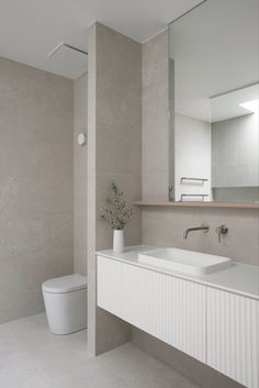 a bathroom with a sink, toilet and large mirror above the sink is featured in an instagram