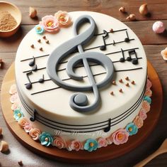 a cake decorated with music notes and flowers on top of a wooden table next to spoons