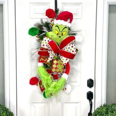 the grinch door hanger has been decorated with green and red christmas wreaths