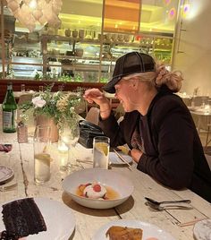 a woman sitting at a table with plates of food