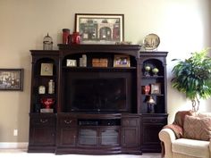 a living room with a large entertainment center in the corner and a couch next to it