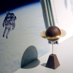 an object on top of a wooden stand in front of a book and space shuttle