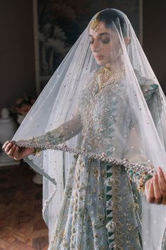 Elegant Ice Blue Embroidered Pakistani Wedding Dress Gown Pishwas is an ethereal creation that's a work of art. Ice blue tulle comes alive with scintillating florals, and iridescent details accentuate the overall composition. Hand-placed sequins, crystals, and seed pearls add a touch of glamour to the silver and silk thread-worked blooms. The dreamy organza dupatta features intricately embroidered borders and elaborately worked pallus, making it a showstopper that's sure to captivate. With its c Pakistani Wedding Dress, Chiffon Collection, Blue Tulle, Pakistani Bridal Dresses, Organza Dupatta, Pakistani Bridal, Pakistani Outfits, Pakistani Wedding, Silk Thread