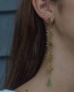 SWINGING STARS WHAT IT IS: Extra-long drop earrings consisting of bright gold dangling stars WHY IT’S SPECIAL: These magical earrings are made for daydreamers and moon chasers At 5" long, they're a sleek shiny statement, that is surprisingly easy to pull off GOOD TO KNOW: Hand-hammered brassSterling silver postsNickel- and lead-freeLength: 5” WHY WE LOVE WE DREAM IN COLOUR: Create a moment—every moment—you’re wearing We Dream in Colour. We love how they use all the hues of the rainbow and we are Gold Star Charm Jewelry For Festival, Gold Festival Jewelry With Star Charm, Magical Earrings, Star Earrings Dangle, Extra Long Earrings, Long Gold Earrings, Minimalist Studs, Thread Earrings, Gold Statement Earrings