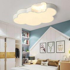 a bed room with a neatly made bed and a white cloud shaped light above it