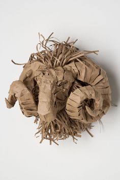 a pile of brown tissue paper sitting on top of a white table next to a wall