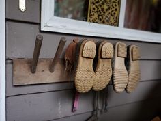 several pairs of shoes are hanging on the wall