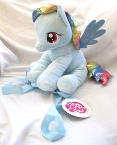 a blue stuffed pony sitting on top of a white bed next to a sticker