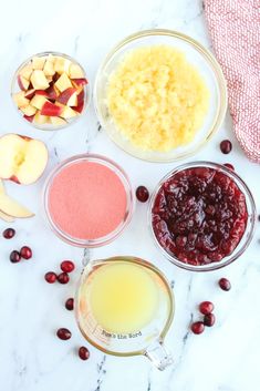 ingredients to make cranberry apple pie laid out on a marble counter top with apples, orange juice and other ingredients