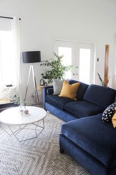 a living room with blue couches and pillows