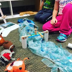 two children sitting on the floor playing with toy boats and other toys in front of them