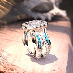 a diamond ring sitting on top of a wooden table next to a white and blue stone