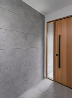 a wooden door in front of a concrete wall