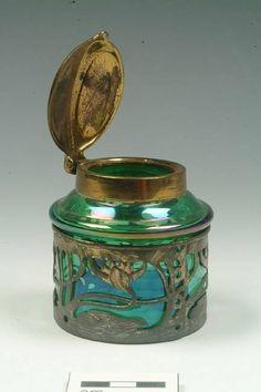 a green glass jar with a gold lid