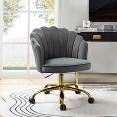 an office chair in front of a window with a rug on the floor next to it