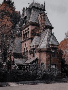 an old building with a clock tower on it's roof and ivy growing around the corner