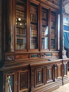 an old wooden bookcase with many books on it's shelves in a room