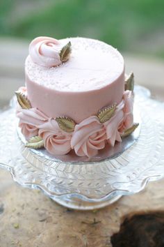 a pink cake on a glass plate with flowers