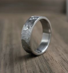 Here I present to you a handmade hammered titanium ring. This ring is suitable for men and women as it is classic in a minimalist style and is therefore suitable for all occasions as well as everyday wear. The ring presented is made in US size 8 1/2 and is 6 mm wide. You can choose between different sizes and widths. This titanium wedding band is not only visually stunning, but also comfortable to wear. The smooth interior ensures a comfortable fit, while the durable titanium provides a lightwei Industrial Ring, Minimalist Wedding Band, Titanium Wedding Rings, Husband Anniversary, Titanium Wedding Band, Titanium Ring, Hammered Ring, Hammered Rings, Titanium Rings