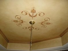 the ceiling is painted with gold paint and has an ornate design on it, as well as a chandelier