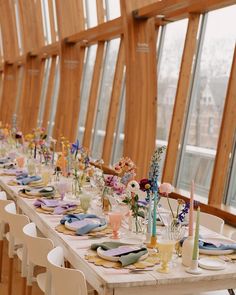 a long table is set with plates and flowers