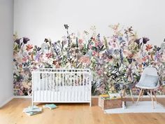 a white crib in front of a floral wall mural