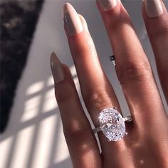 a woman's hand with a ring on it and a diamond in the middle