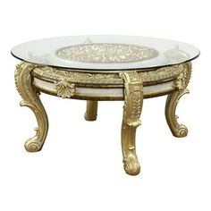 a glass and gold coffee table with an ornate design on it's bottom shelf