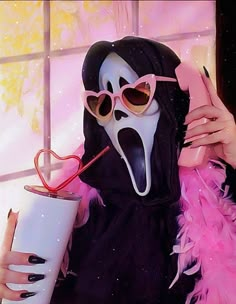 a woman wearing a mask and holding a drink in front of a window with pink feathers