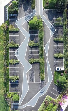 an aerial view of a parking lot with trees and plants on the side of it